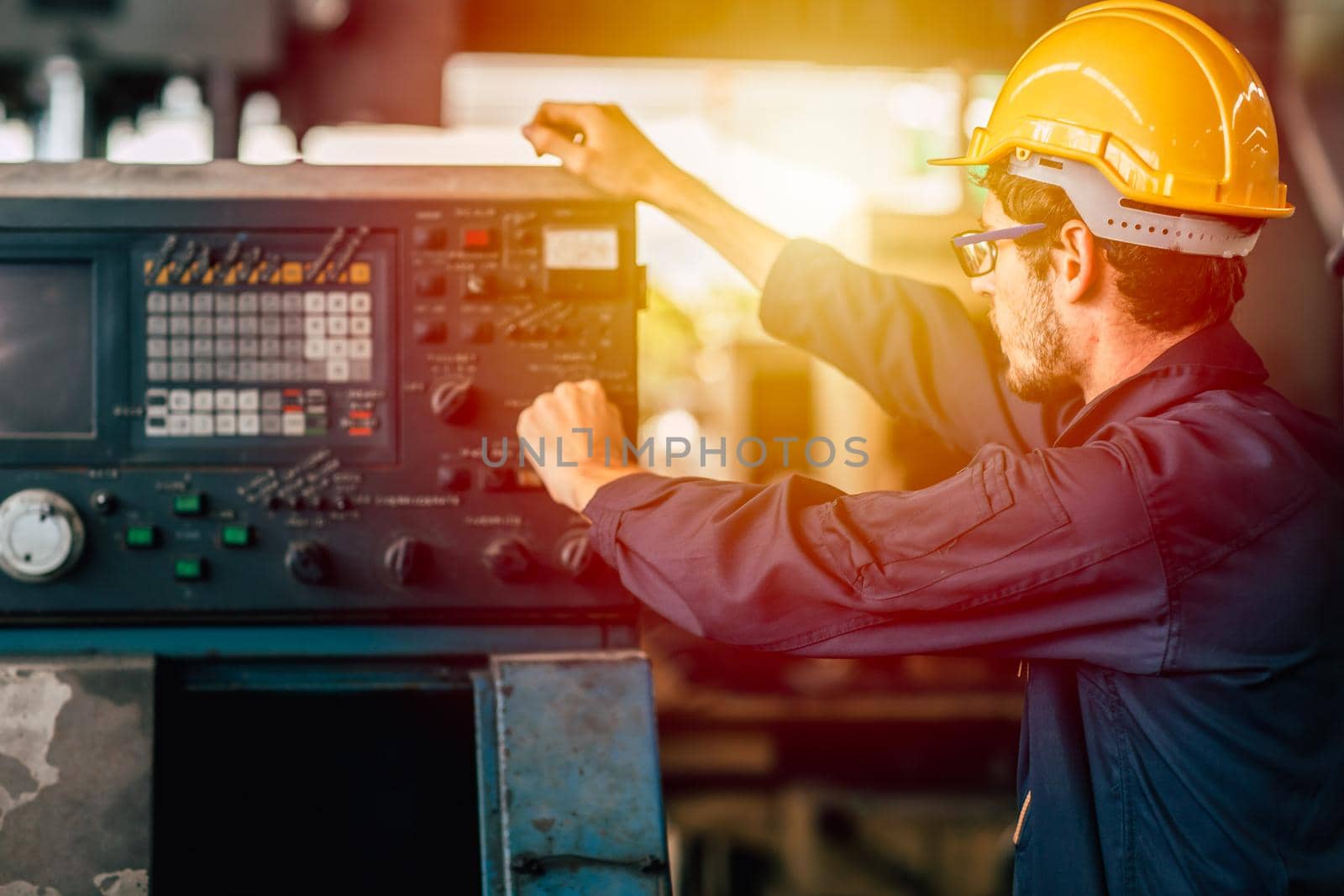 Young American worker intend to work in a heavy industrial factory. Engineer operate the machine in facility. by qualitystocks