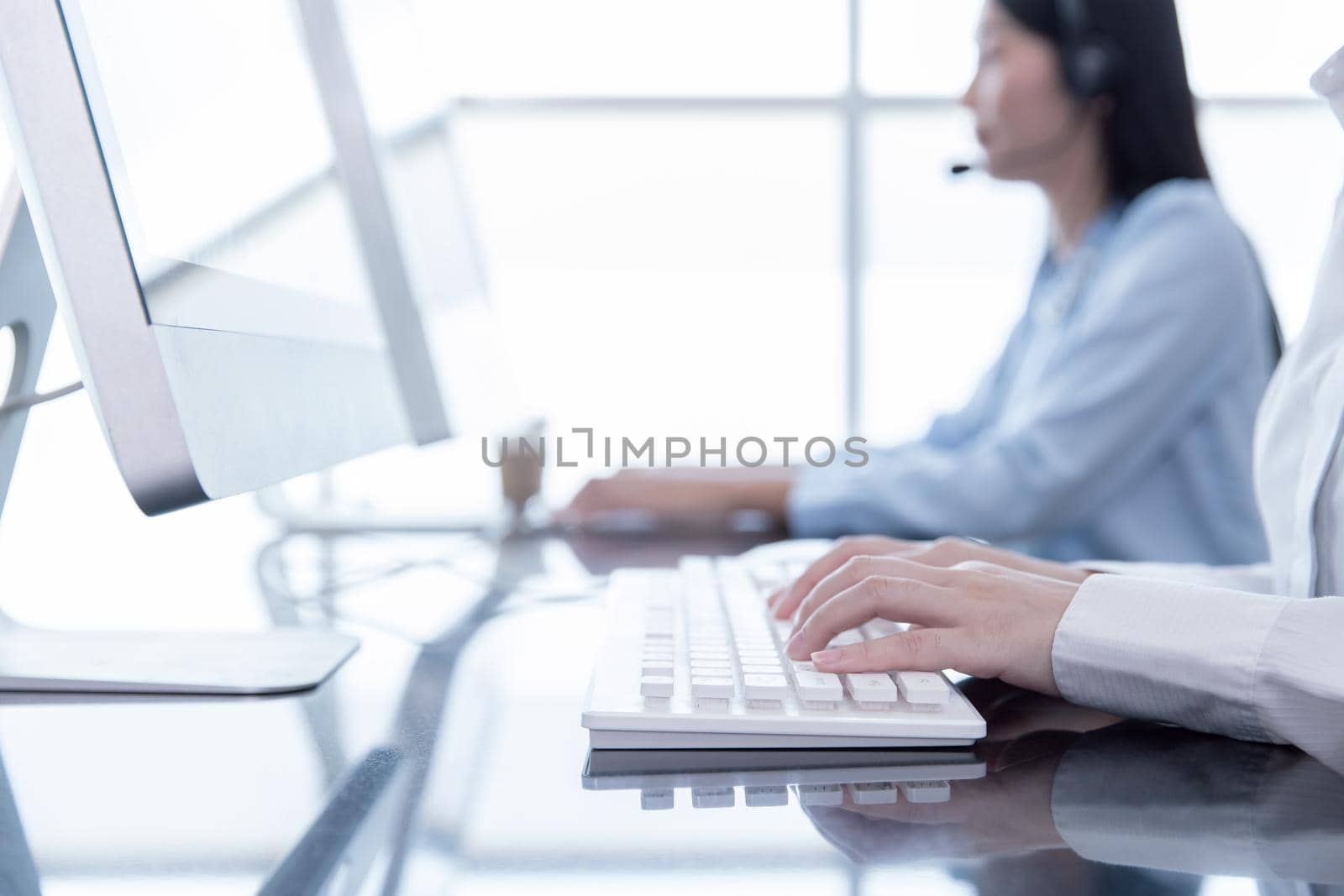 Closeup hand officer typing record customer data in computer CRM software. People call center working in office  for hotline or telephone support.
