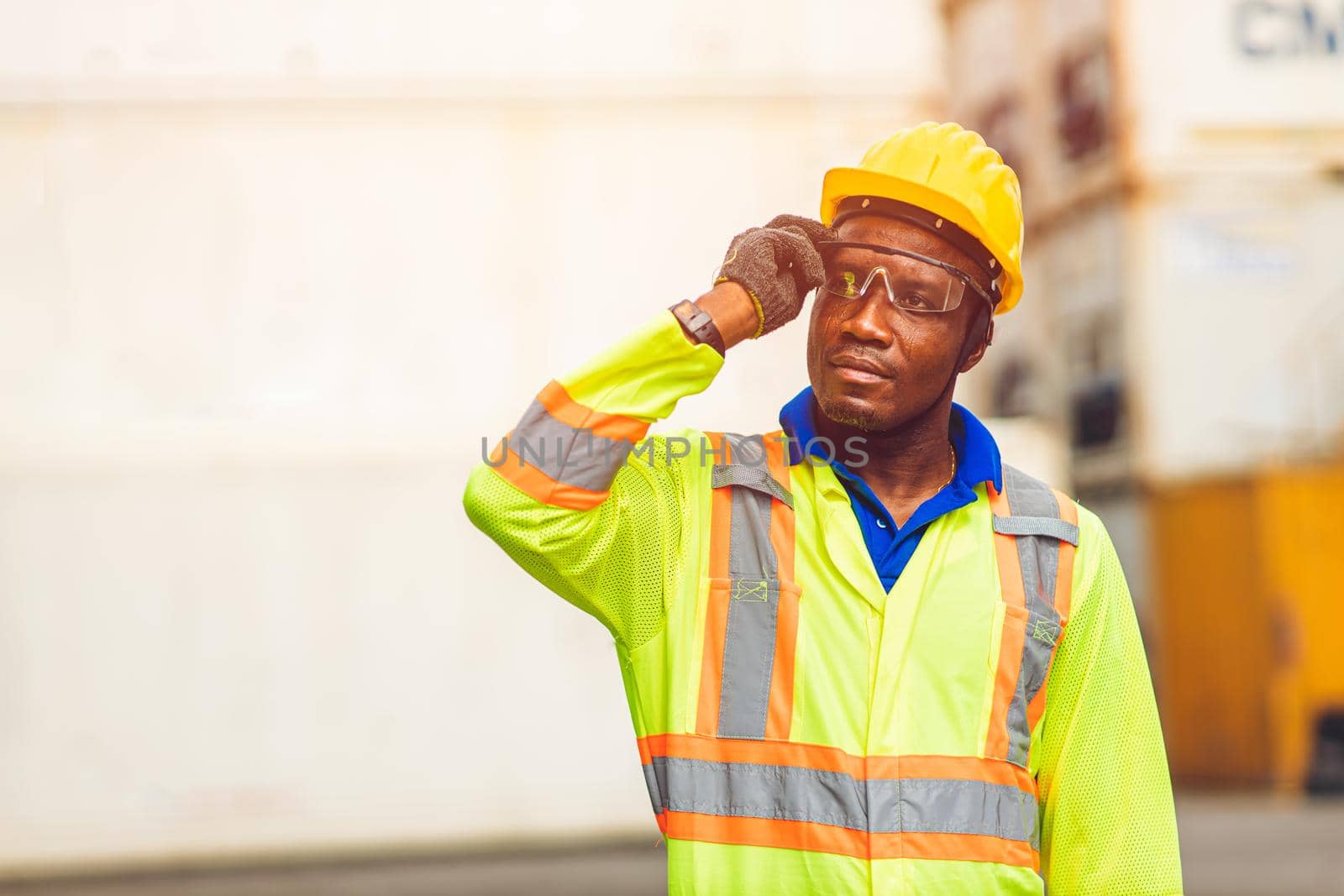 Black African happy worker working in logistic shipping standing confident smart looking containers at port cargo shipping work industry.