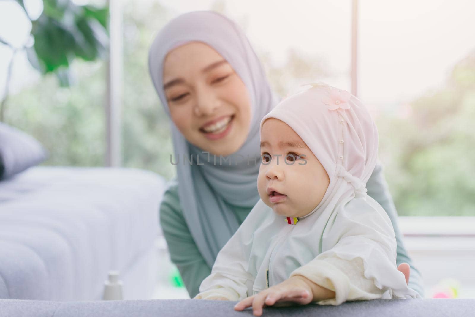 Muslim Mother look at her baby happy smiling infant home care together cute lovely childhood indoor.