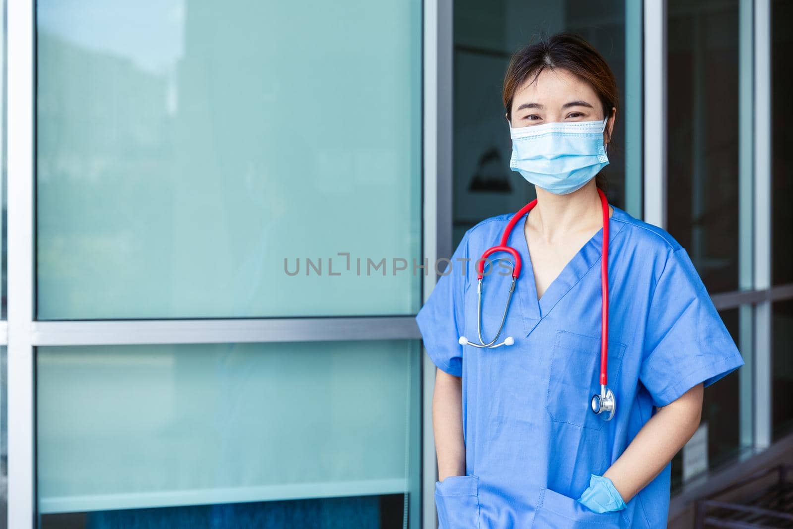 Portrait Doctor or Nurse standing confident looking camera with face mask at hospital building.