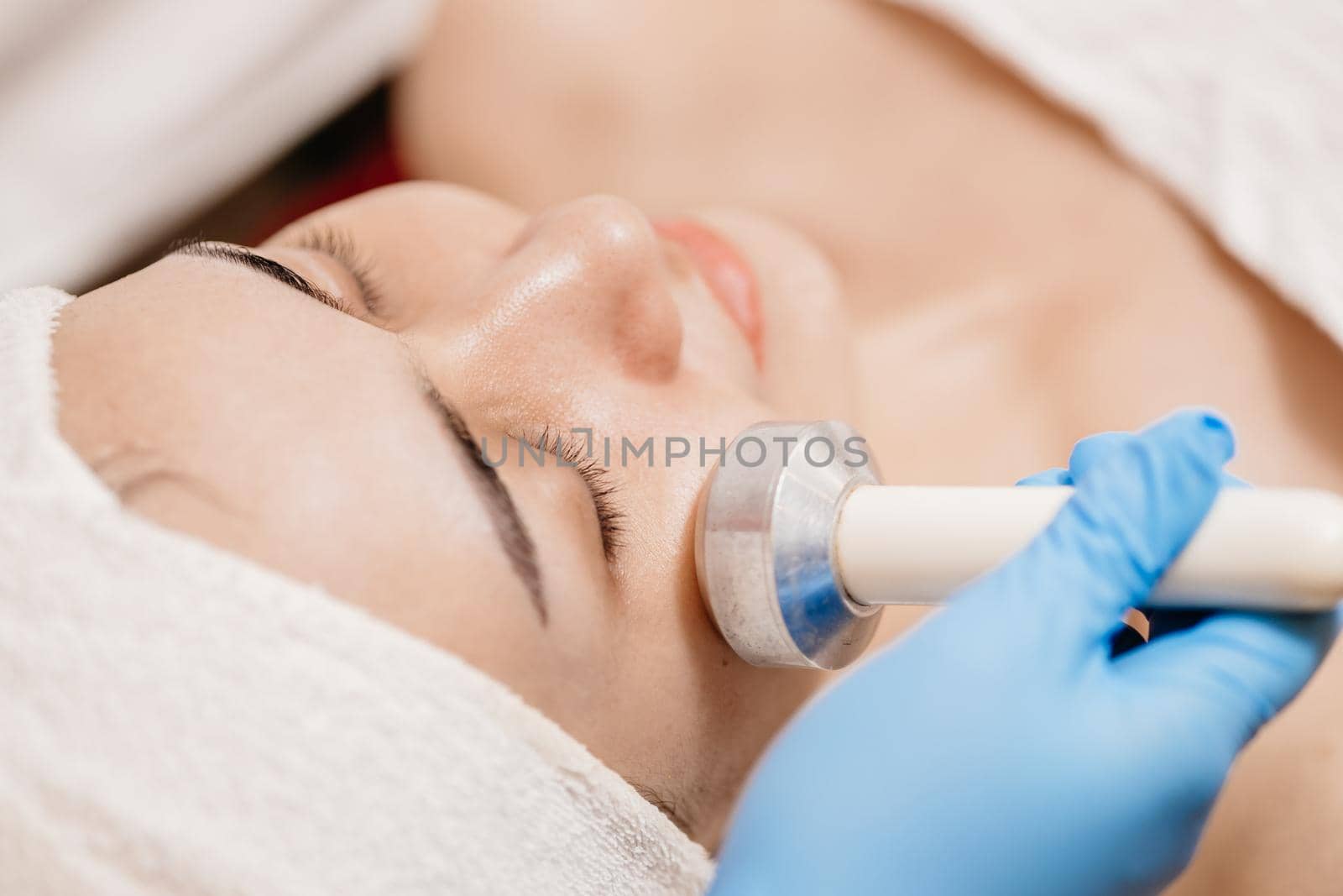 closeup people using Ultrasonic massage device for Facial Lifting Activate Collagen and Skin Tightening in beauty salon spa.