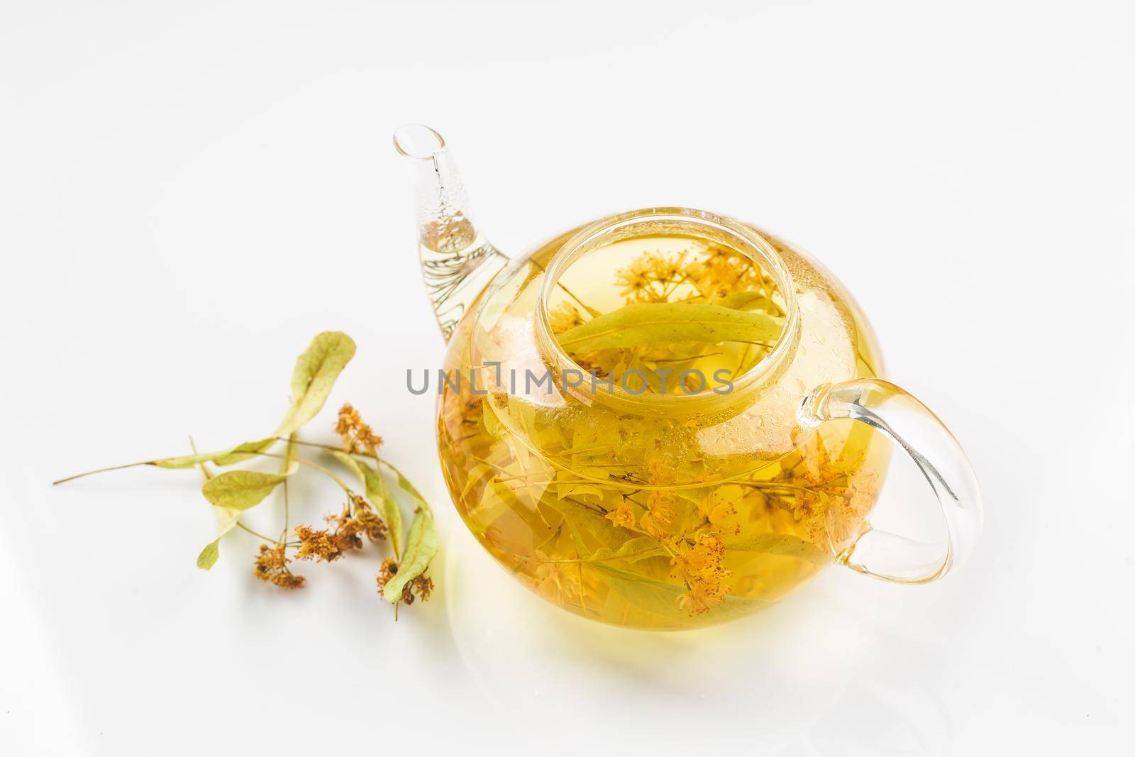 Linden or tilia tea in the transparent tea pot by Syvanych