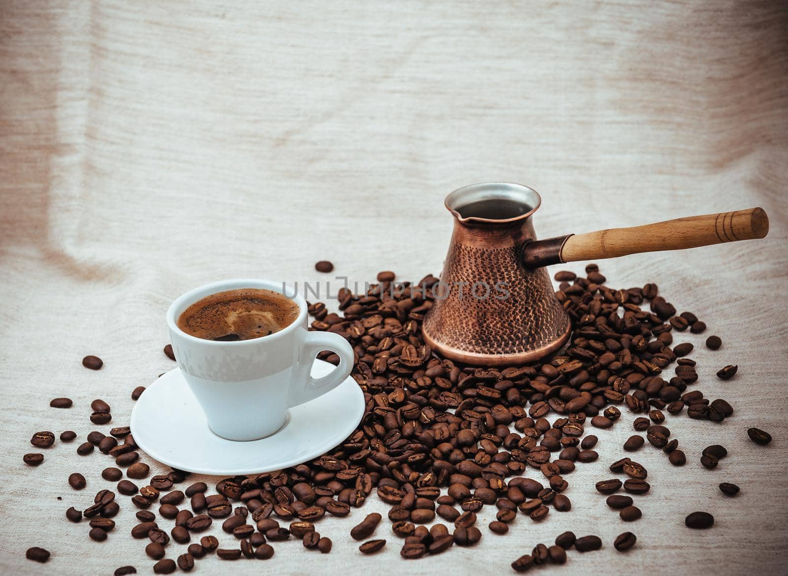 Coffee turk and cup of coffee on burlap background. coffee beans isolated on white background. roasted coffee beans by Andrii_Ko