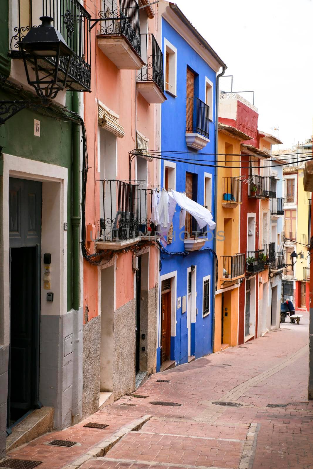 Villajoyosa, Alicante, Spain- April 22, 2022:Narrow cobbled street and beautiful colorful facades in Villajoyosa village, Alicante, Spain