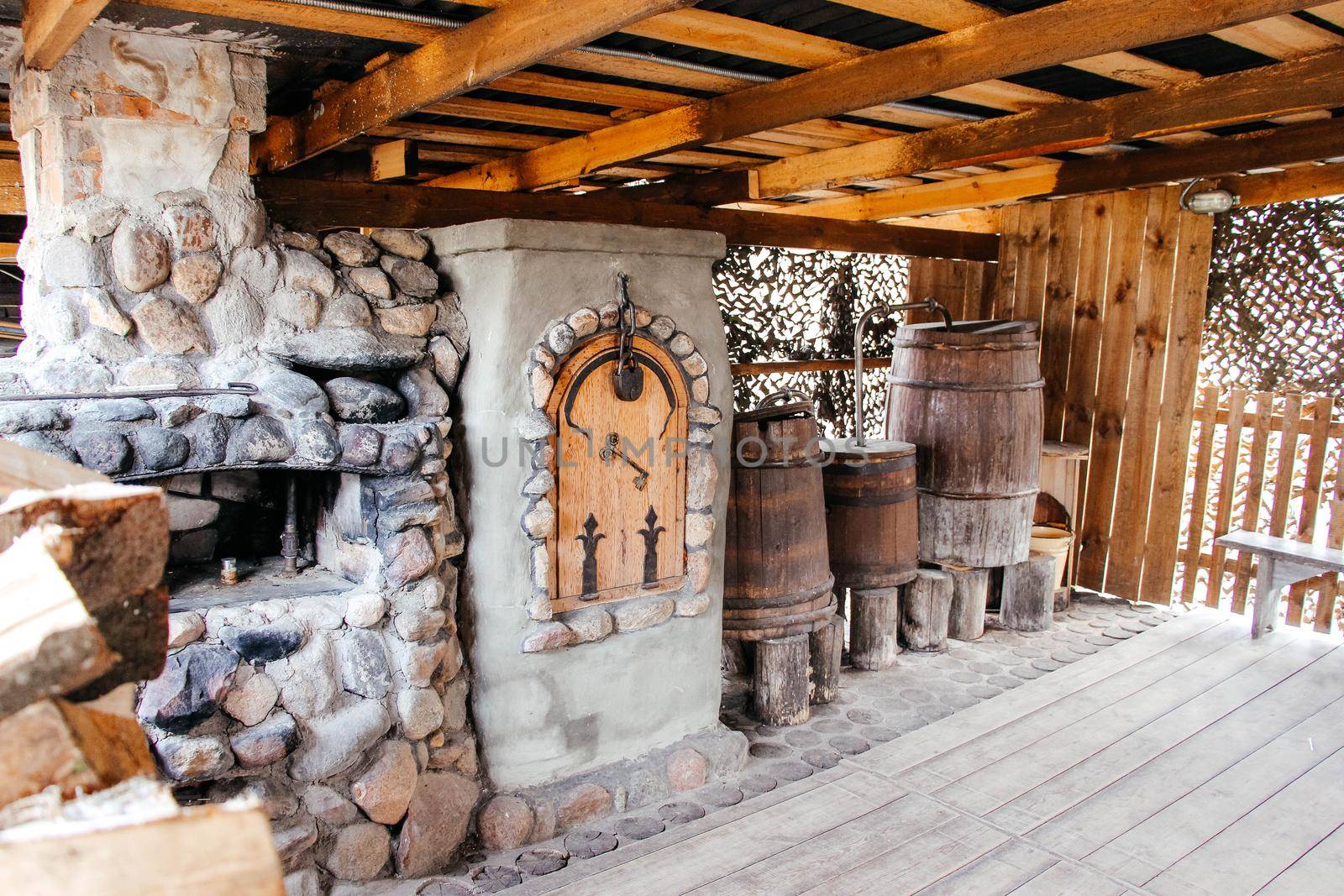 Old Slavic village street cooking stove with stack of firewood nearby . High quality photo