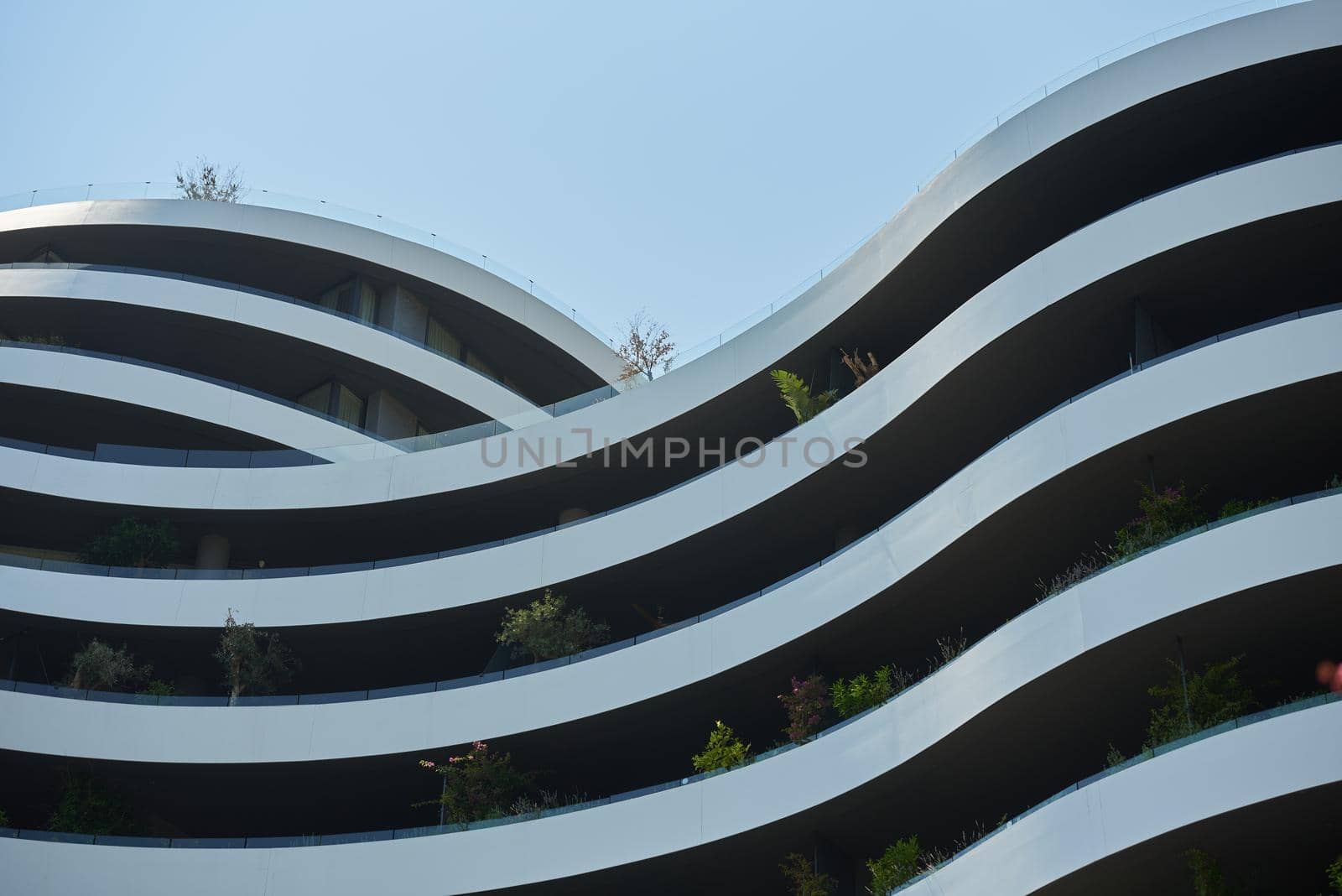 Facade of a modern apartments building in europe with plants by iceberg