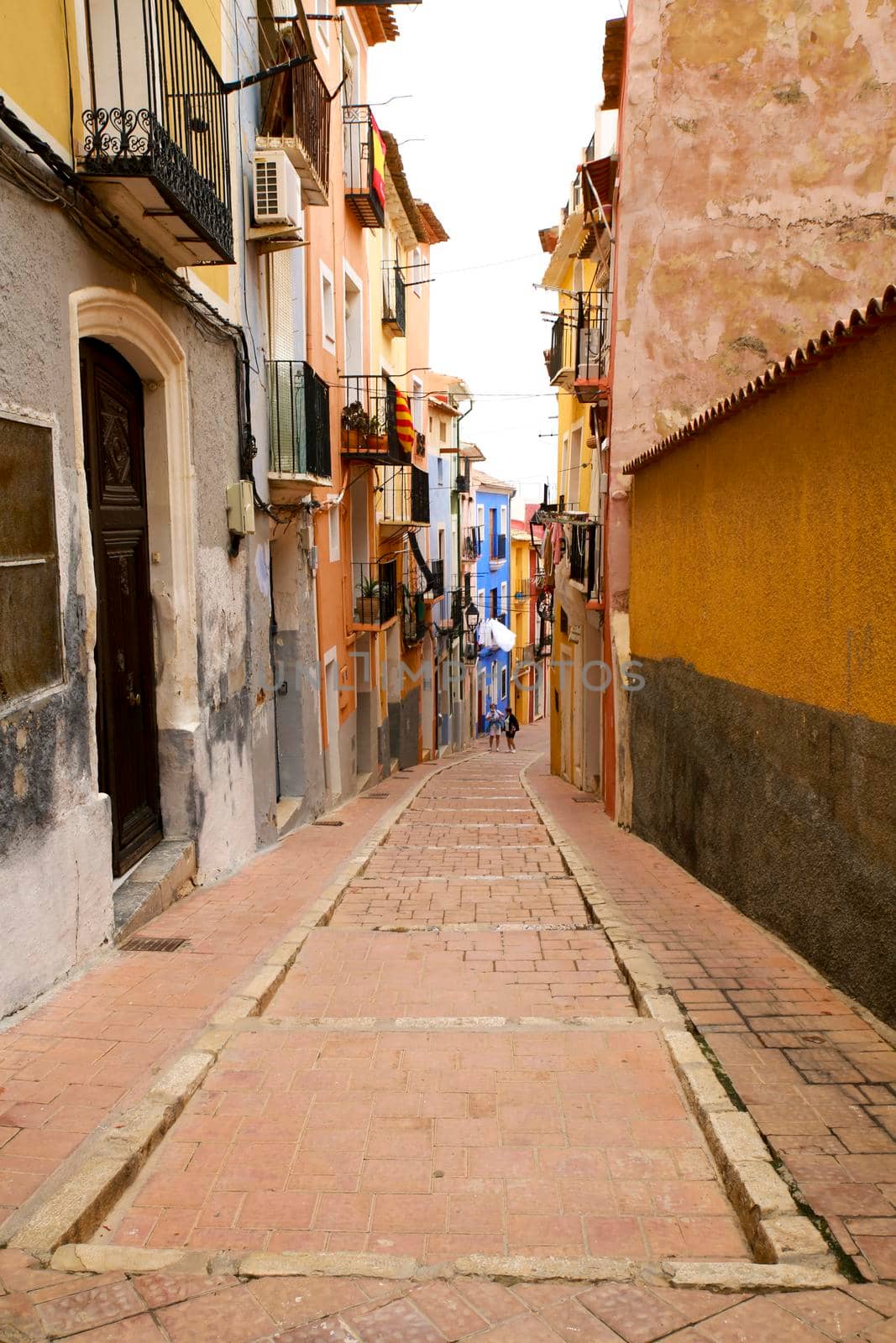 Narrow cobbled street and colorful facades in Villajoyosa town by soniabonet