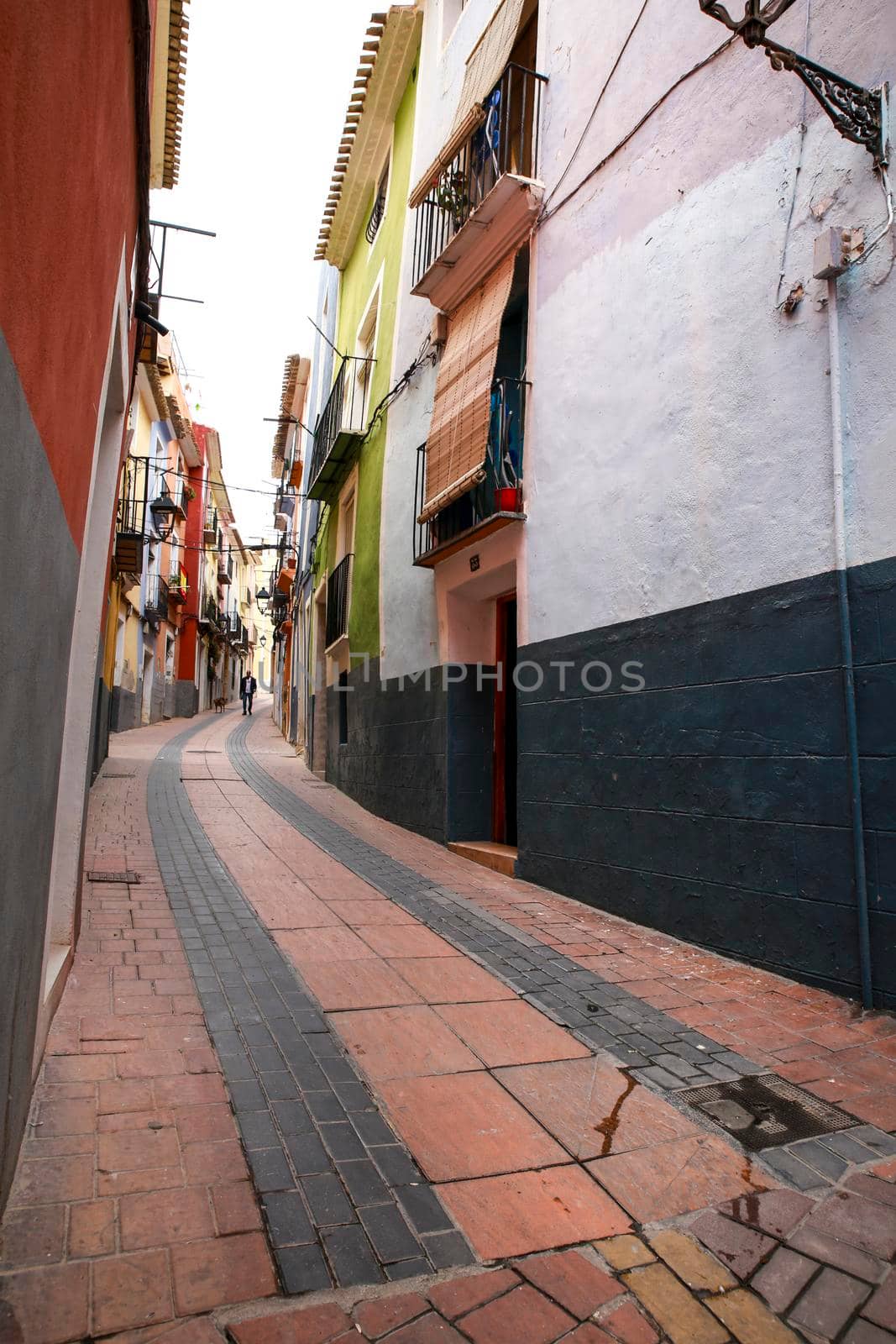 Narrow cobbled street and colorful facades in Villajoyosa town by soniabonet
