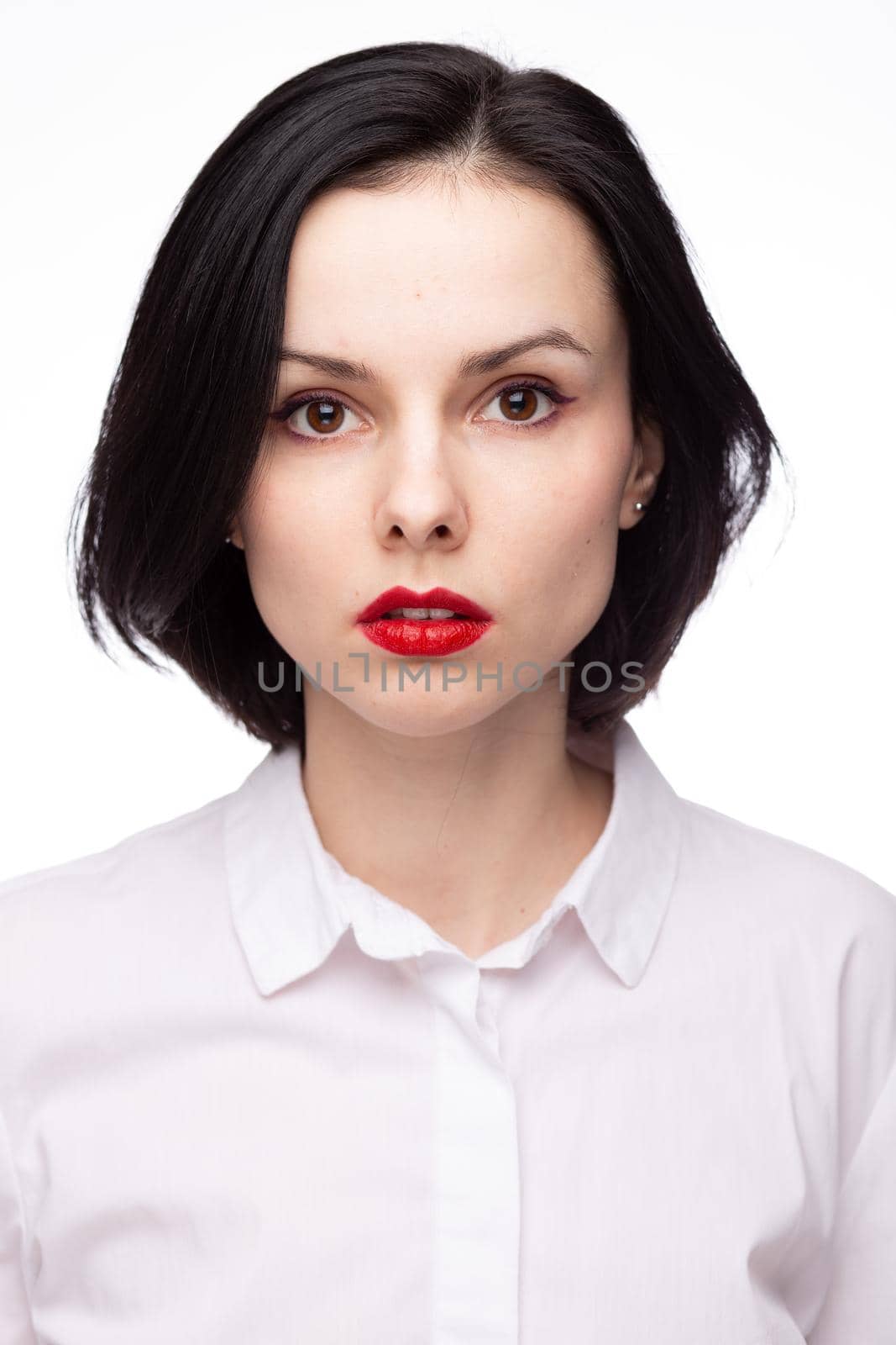 brunette woman with red lipstick on her lips in white shirt, white background. High quality photo