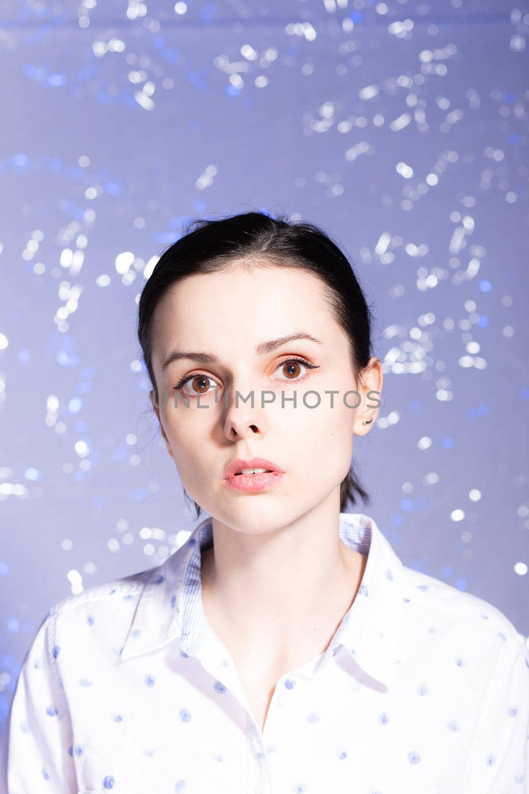 woman in a white shirt with blue polka dots, on a blue background. High quality photo