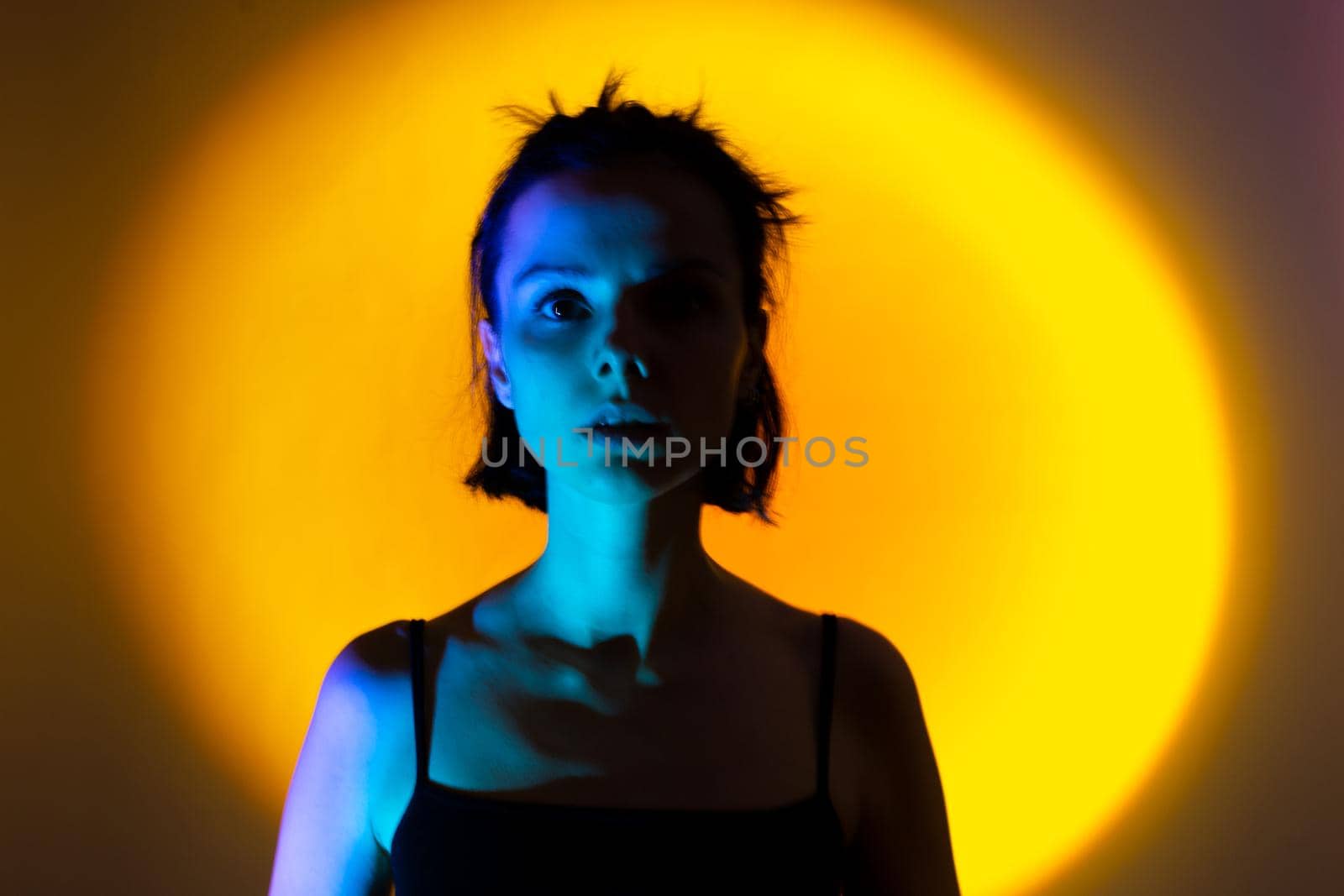 art portrait of a woman with blue light on her face, yellow background,. High quality photo