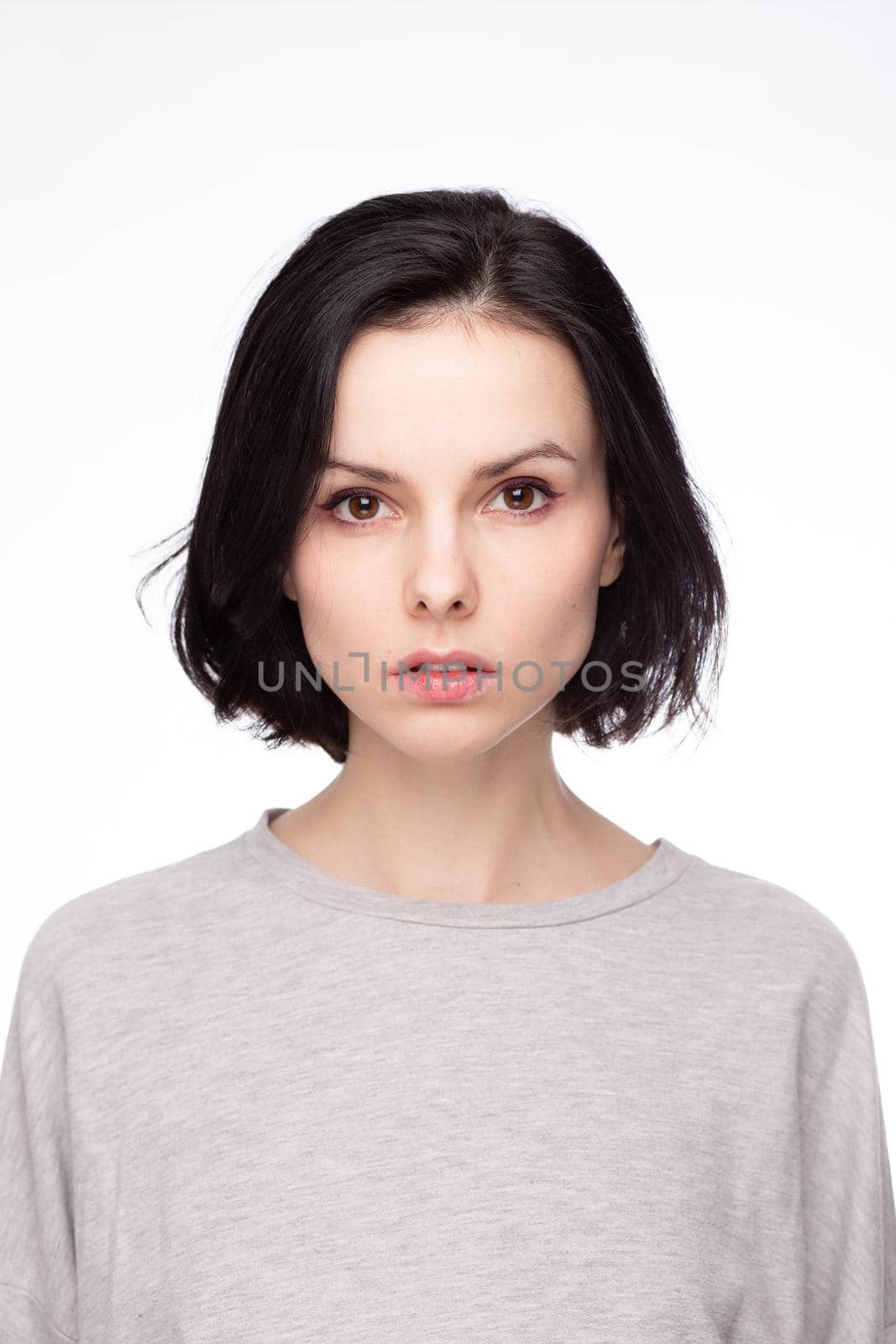 cute brunette woman with gray sweatshirt, white background by shilovskaya