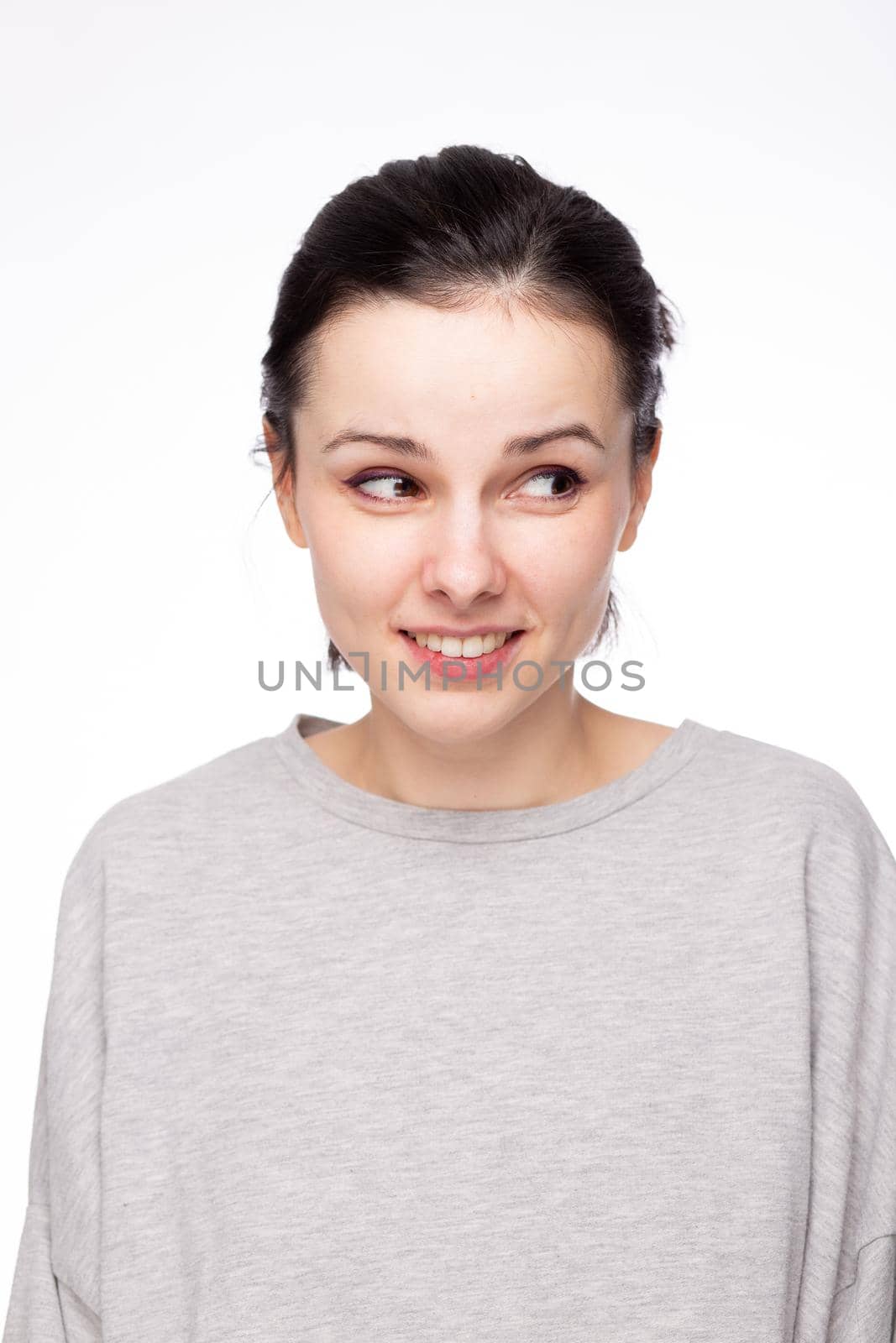 emotional woman in a gray sweatshirt, white background. High quality photo