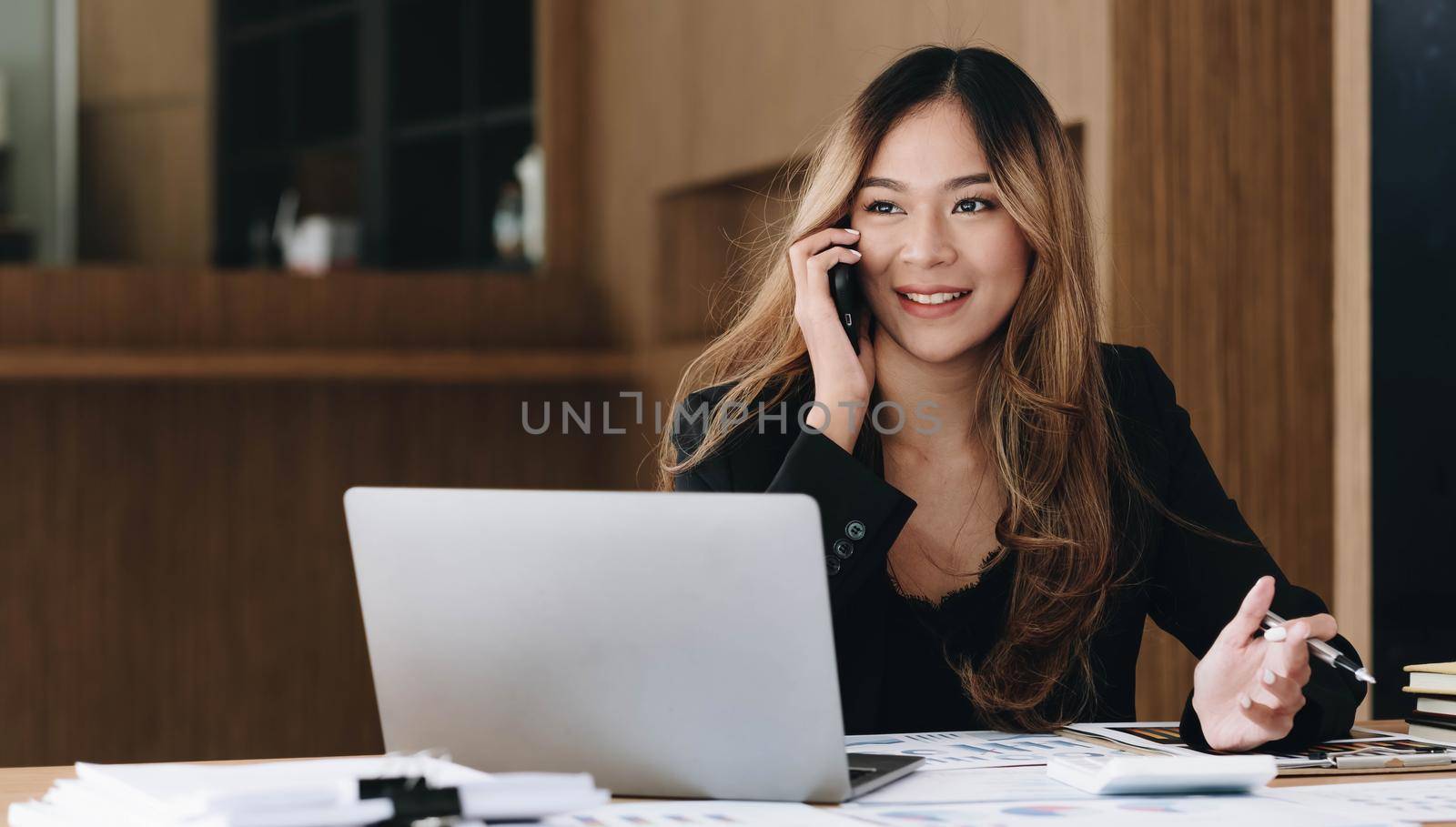 Asian business woman have the joy of talking on the phone, laptop and tablet on the office desk..