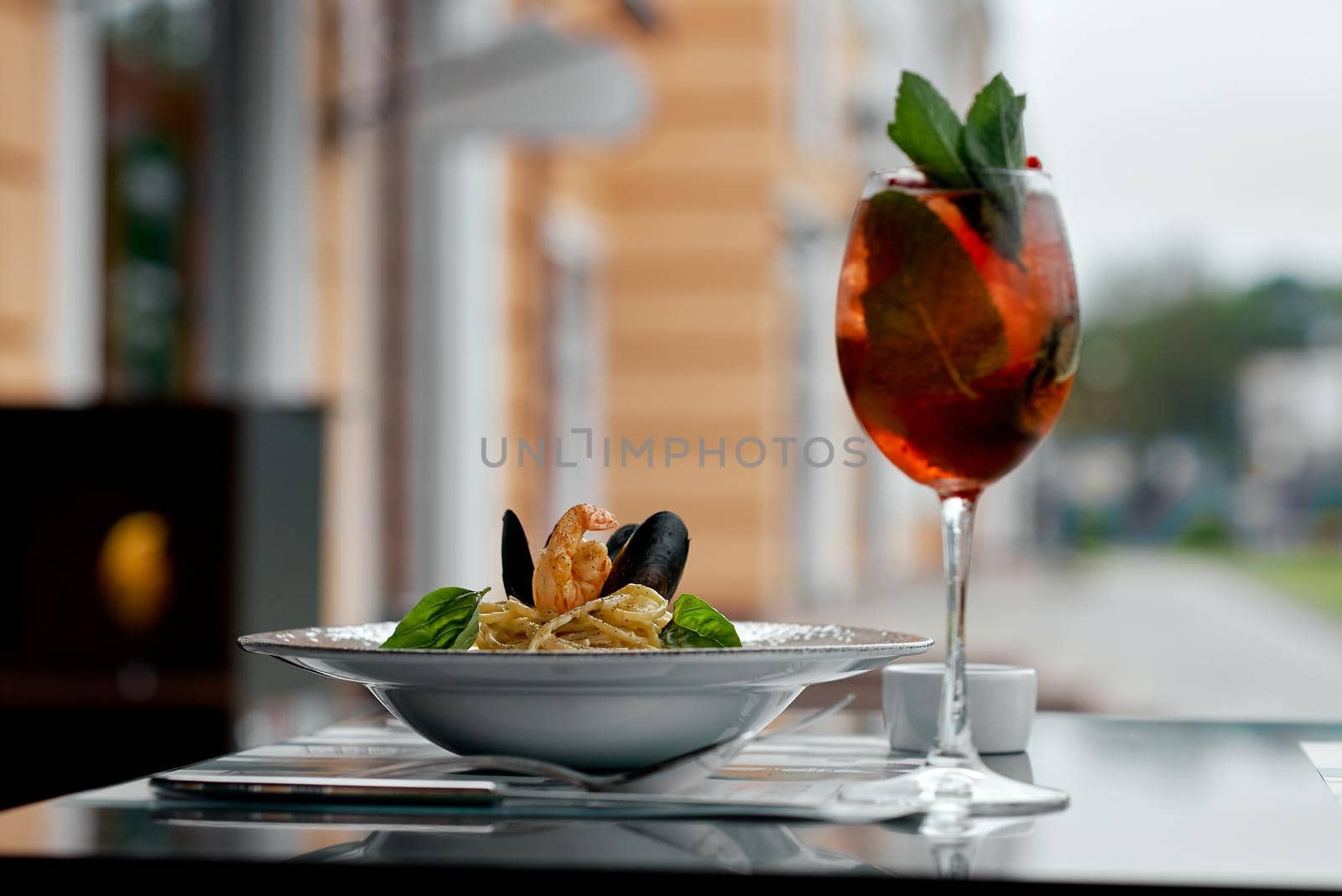 in the cafe a plate with mussels on the table with a glass of alcohol by AntonIlchanka