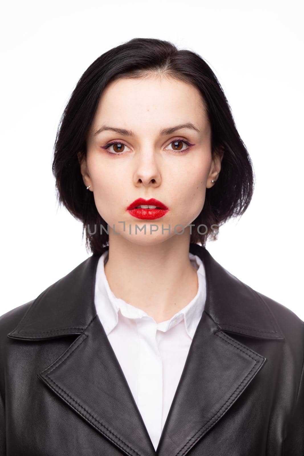 brunette woman with red lipstick on her lips in a black leather jacket and white shirt, white background. High quality photo