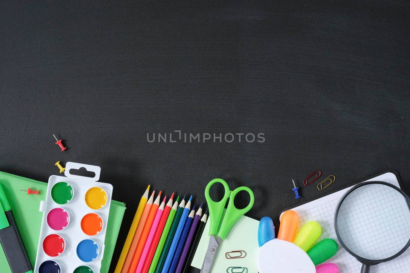 School supplies on black board background. Back to school concept