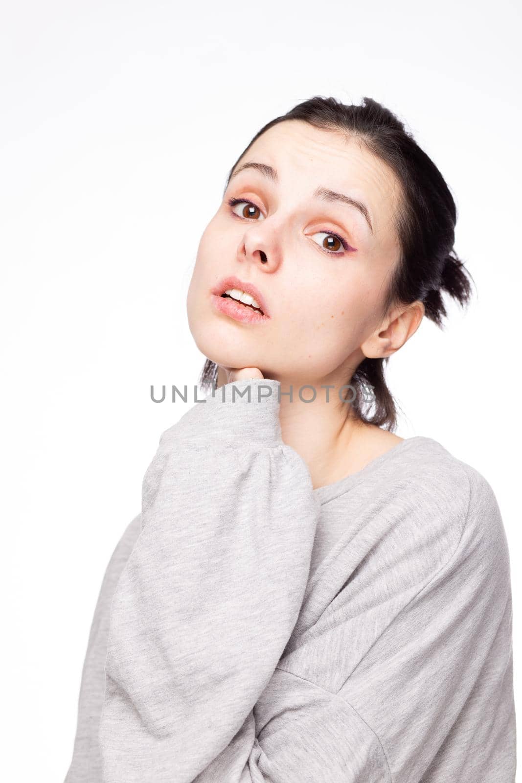 emotional woman in a gray sweatshirt, white background. High quality photo