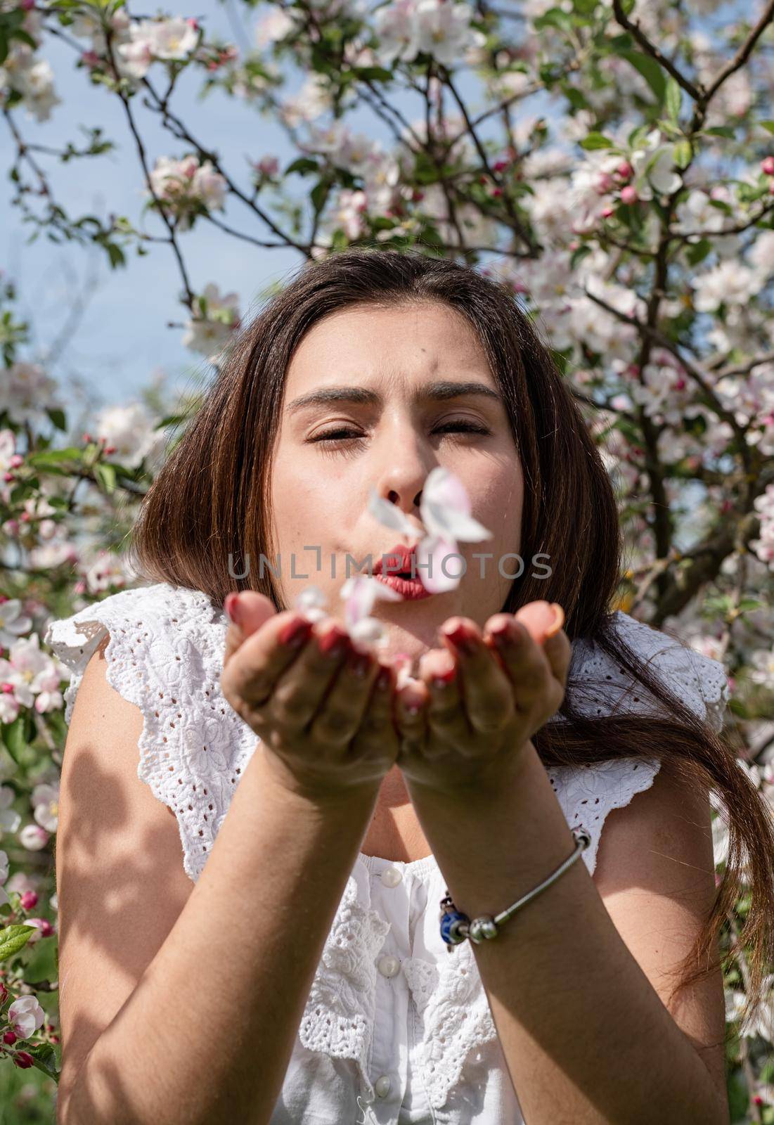 Spring concept. Nature.Young caucasian woman enjoying the flowering of an apple trees, walking in spring apple gardens