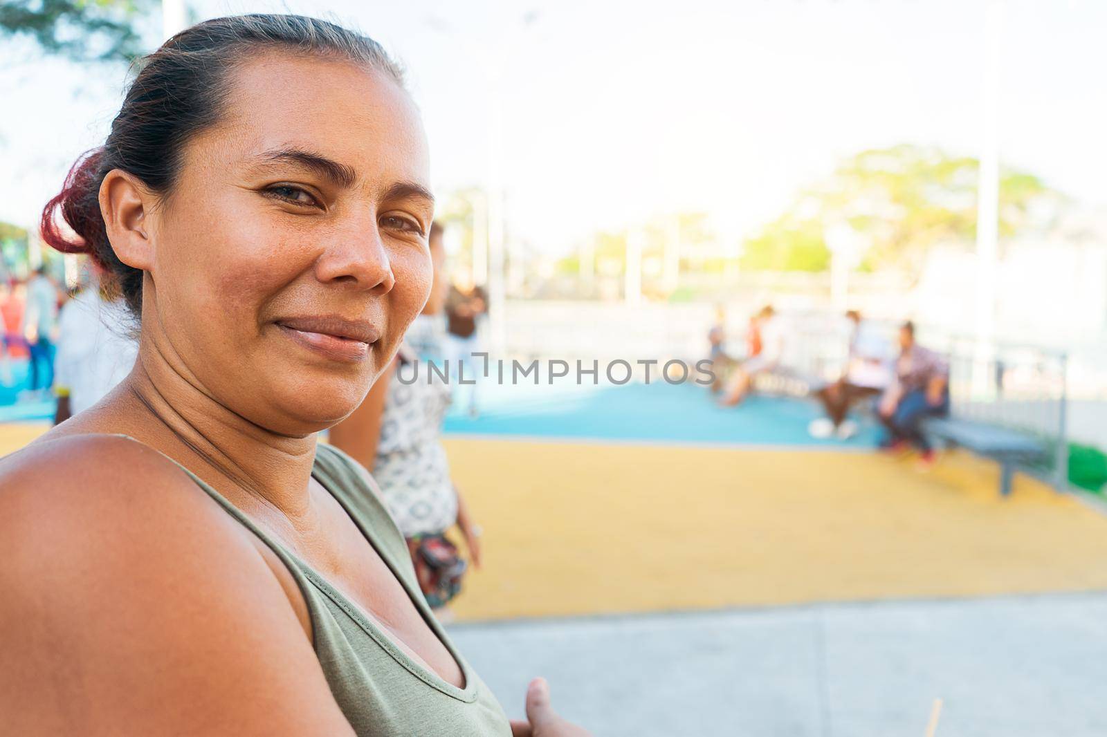 Portrait of a latin woman with green eyes smiling and looking at the camera in an outdoor park in the city of Managua Nicaragua.