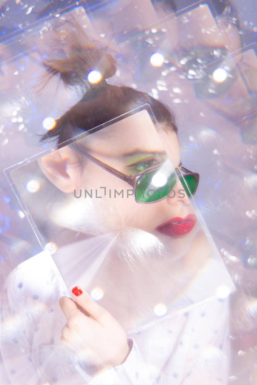 art portrait of a woman in green glasses with red lipstick on her lips in a white shirt. High quality photo