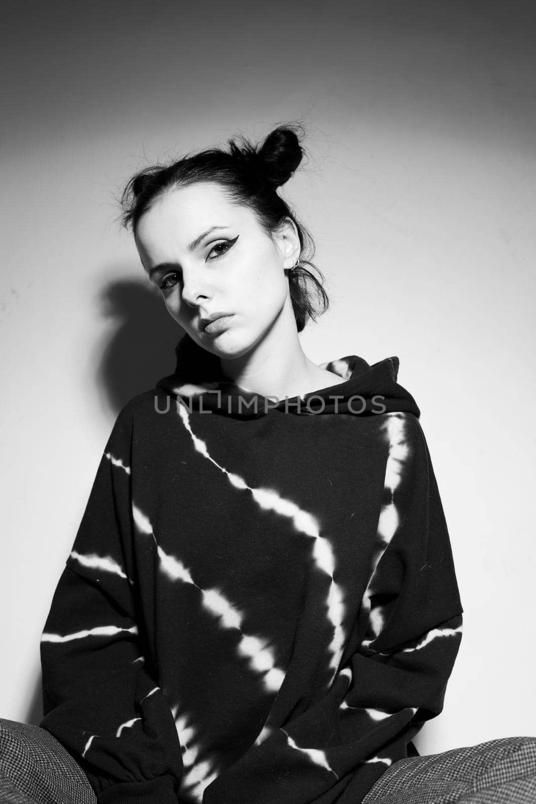 beautiful brunette girl in a black hoodie, light background by shilovskaya