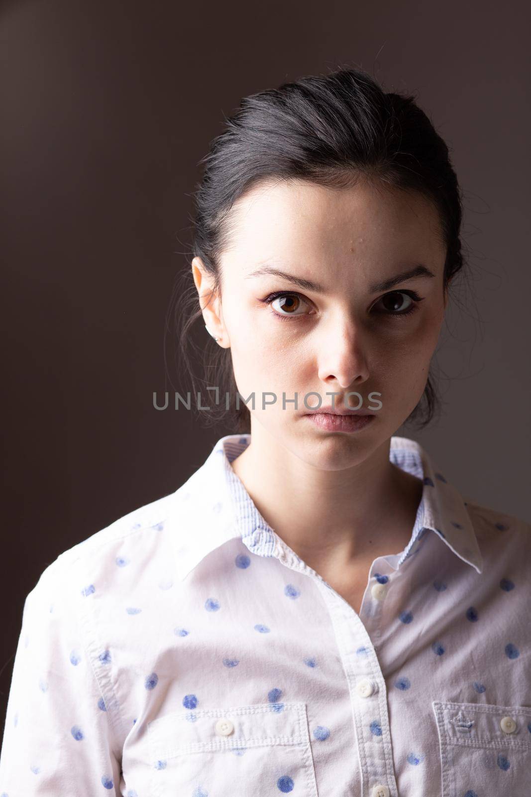 brunette woman in white polka dot shirt. High quality photo