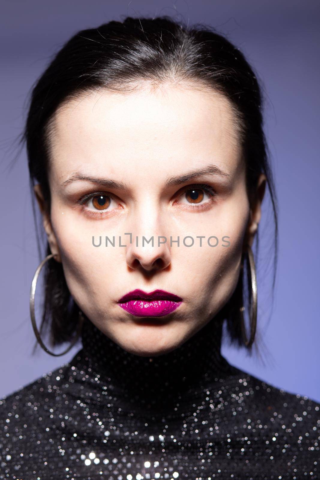 woman with purple lips in a black turtleneck with sequins on a blue background by shilovskaya