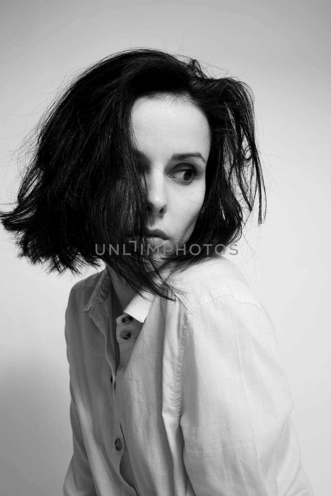 woman in a shirt, light background black and white photography by shilovskaya