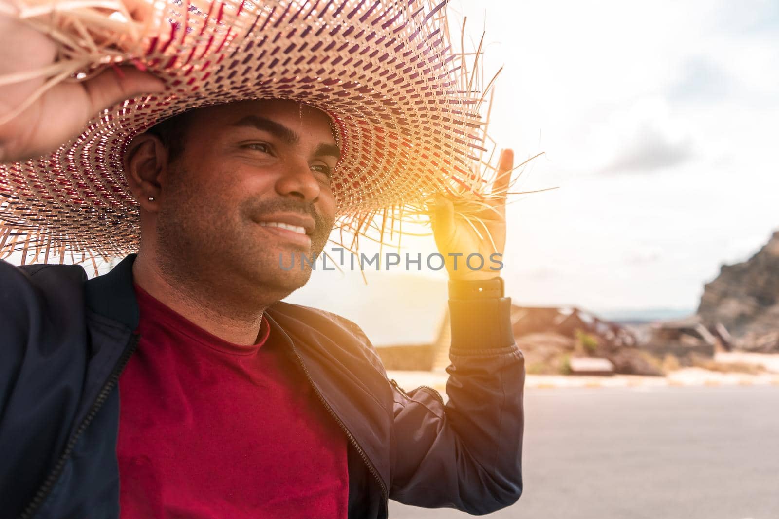 Portrait of a traveling Latino mestizo man wearing a colorful hat and smiling for a walk in an exotic destination of Masaya