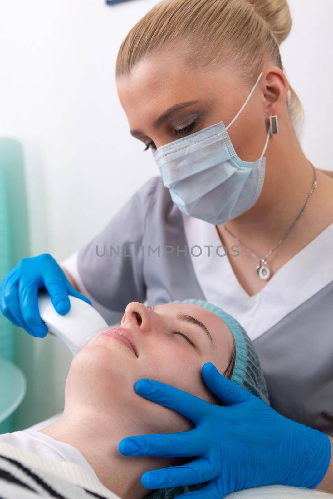 Young woman receiving electric galvanic anti-aging face spa massage at beauty salon. Galvanic massage helps to speed up metabolism, improve regeneration and restore skin protection from harmful external factors.