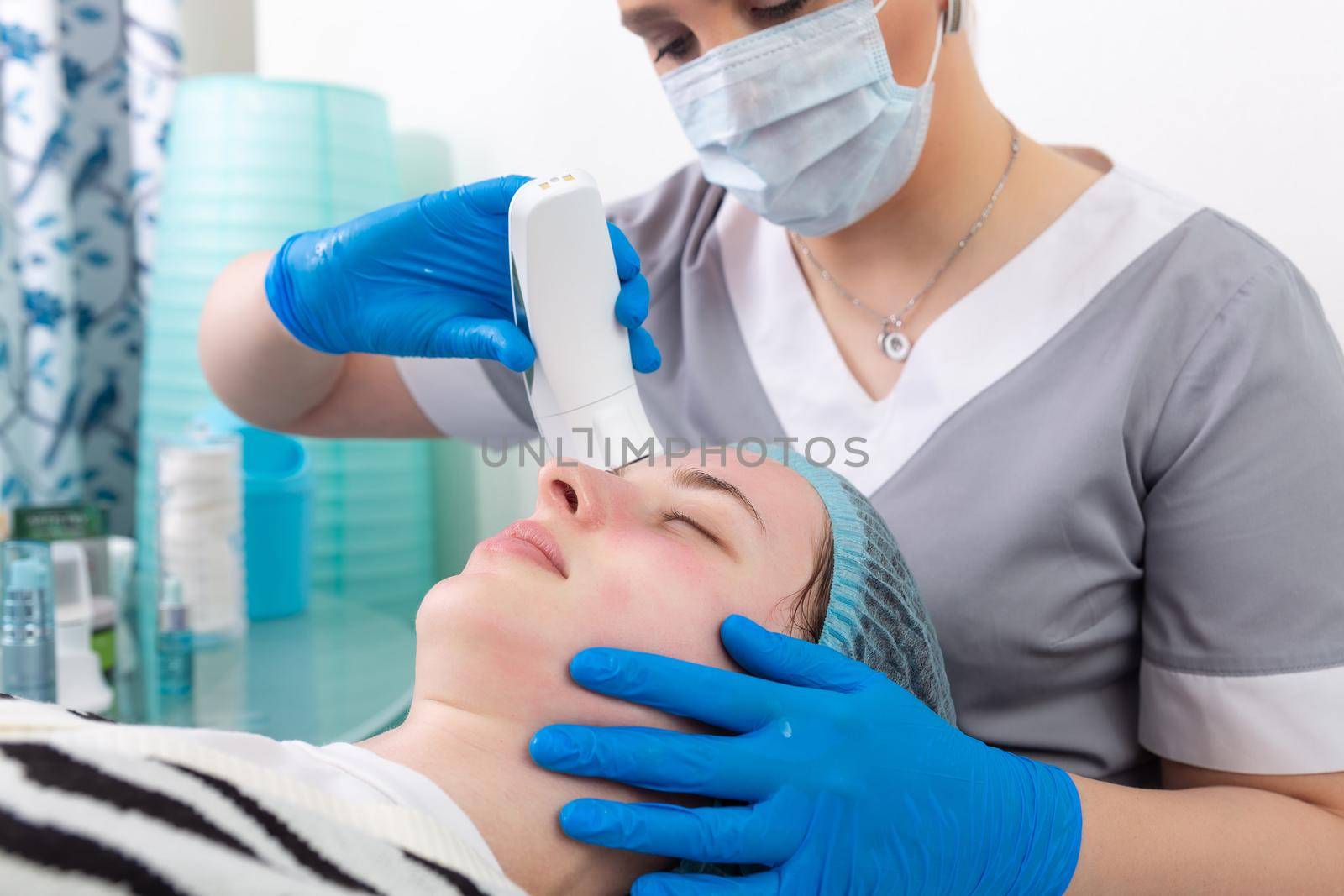 Young woman receiving electric galvanic anti-aging face spa massage at beauty salon. Galvanic massage helps to speed up metabolism, improve regeneration and restore skin protection from harmful external factors.