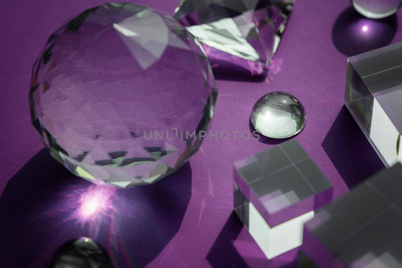 Crystal prism refracting light, magic crystals and pyramid, sphere and cube on purple background. Spiritual healing crystal practice. Feng Shui, good energy flow concept, esoteric background..
