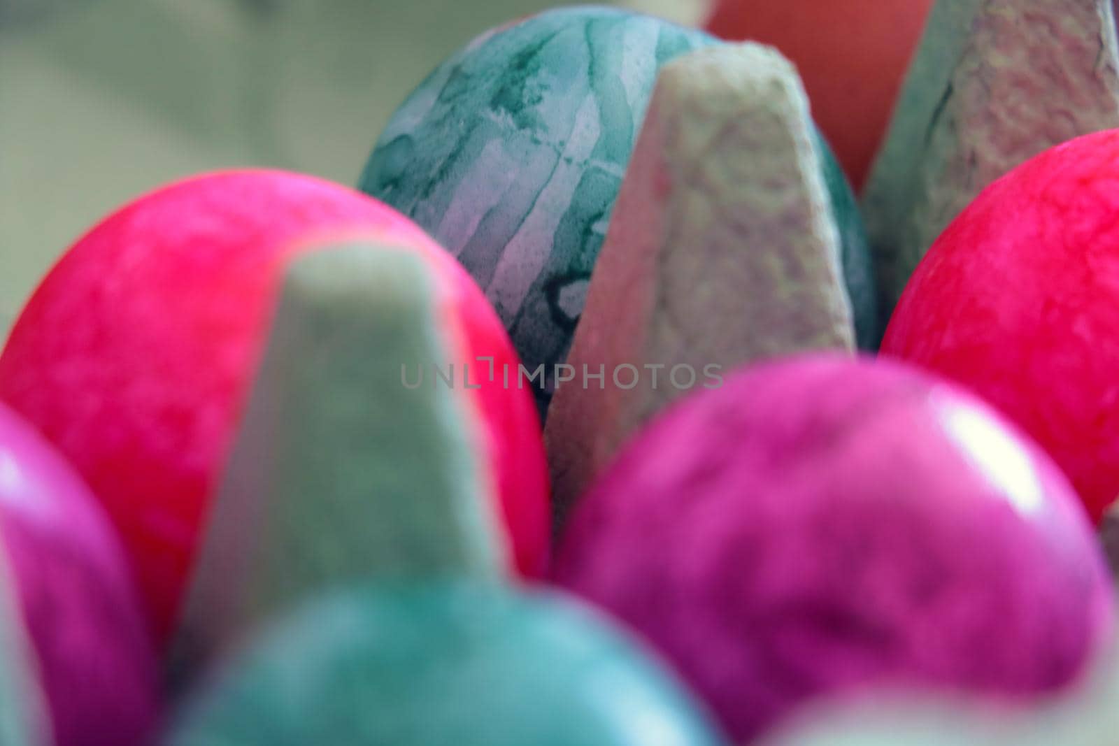 Out of focus. Blurred background. Colored eggs in a box