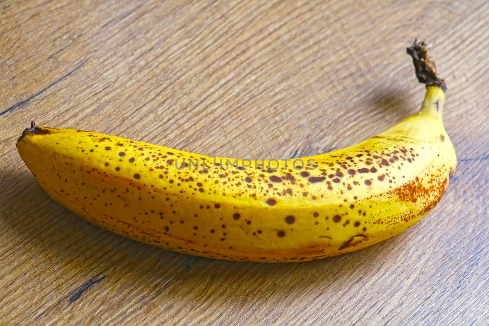 There is a yellow banana on the table. Out of focus, blurred.