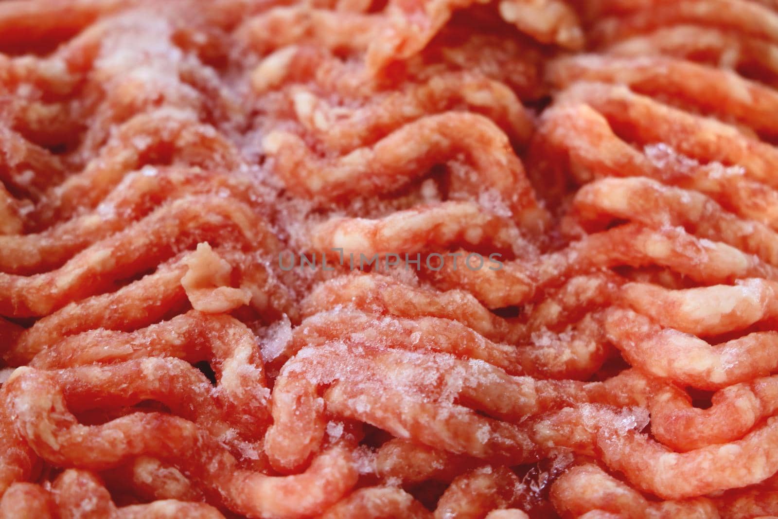 Frozen red fresh minced meat. Background, texture of food. Out of focus, blurred.