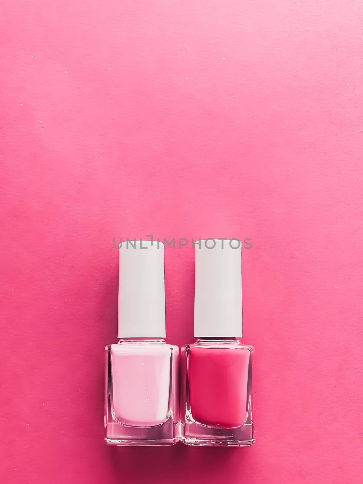 Pink nail polish bottles on rose background, manicure and beauty cosmetics concept