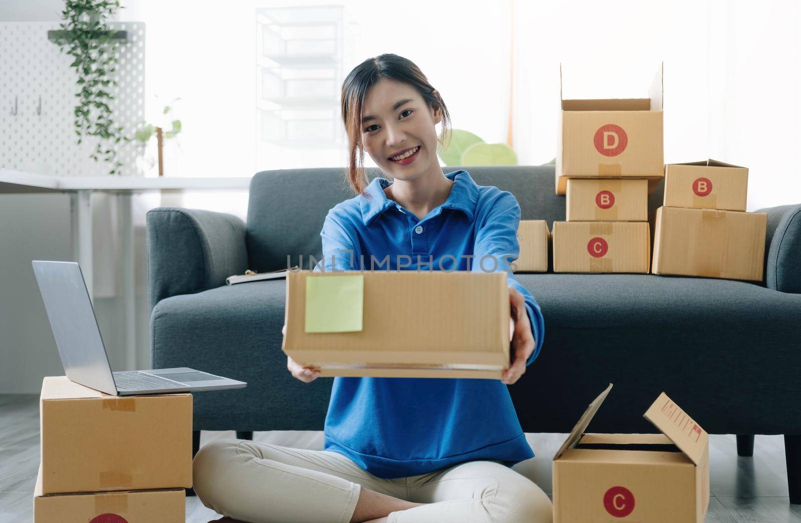 Portrait of Asian young woman SME working with a box at home the workplace.start-up small business owner, small business entrepreneur SME or freelance business online and delivery concept..