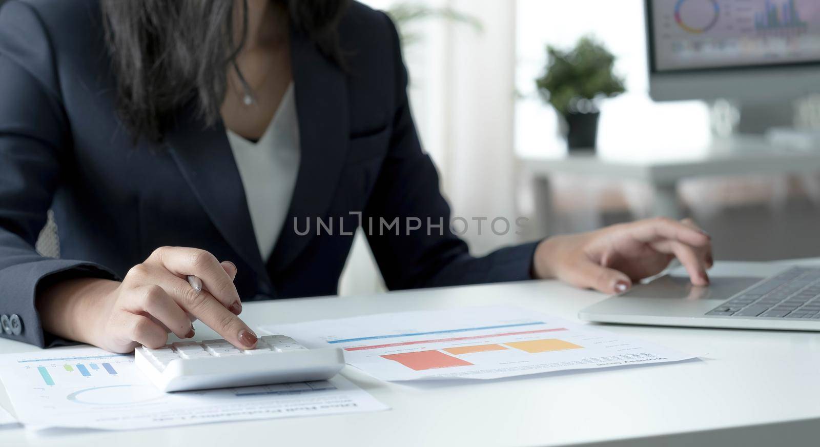 Woman accountant use calculator and computer on desk in office. Work for safe at home. finance and accounting concept.