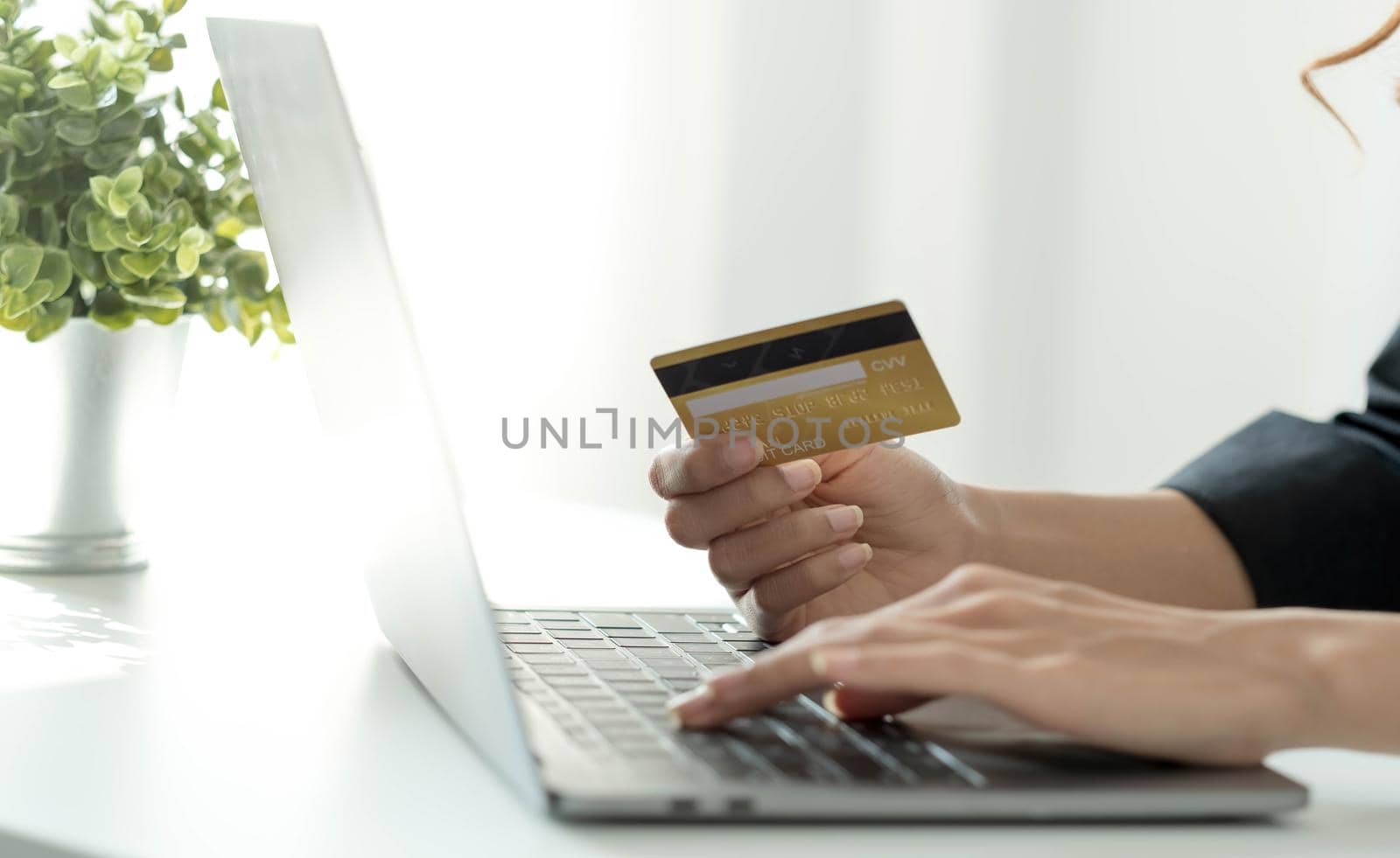 Asian woman checking online order details on computer and use the credit card information entered on the computer..