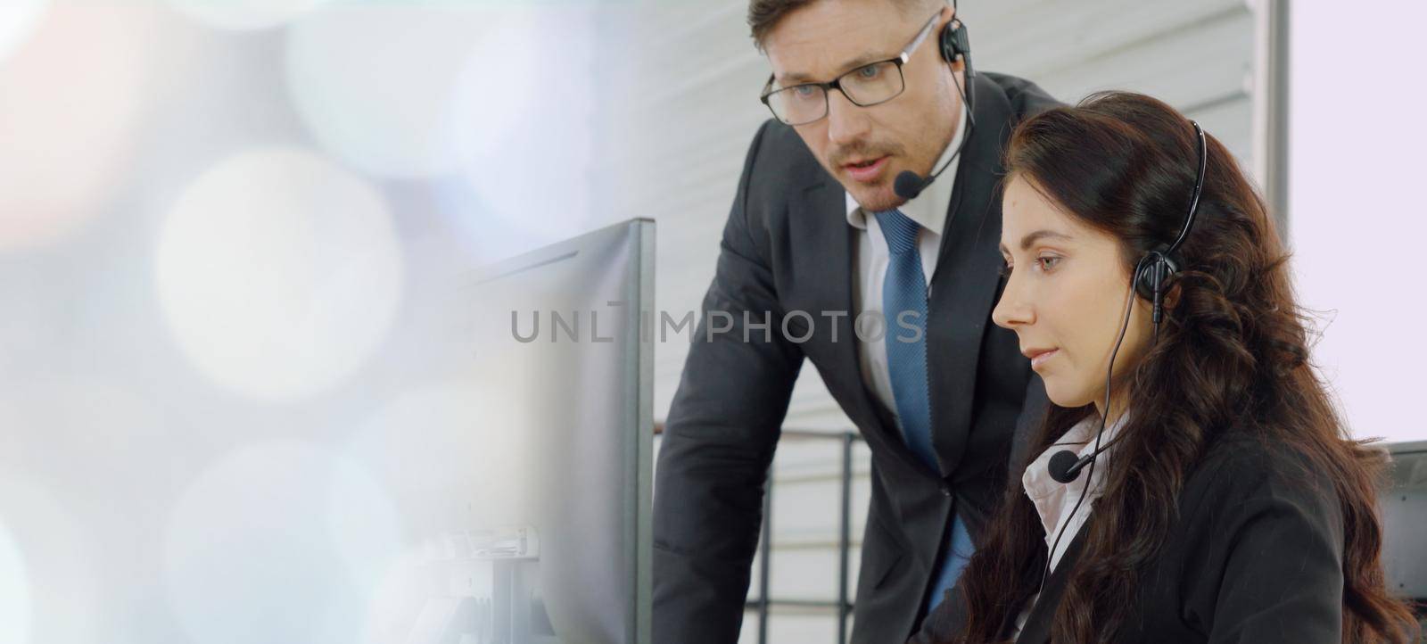 Business people wearing headset working in office to support remote customer or colleague. Call center, telemarketing, customer support agent provide service in broaden view .