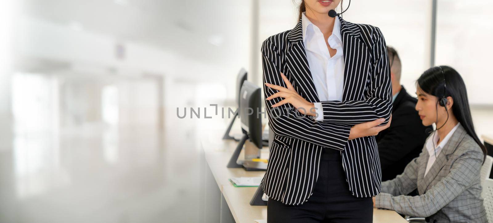 Business people wearing headset working in office to support remote customer or colleague. Call center, telemarketing, customer support agent provide service in broaden view .