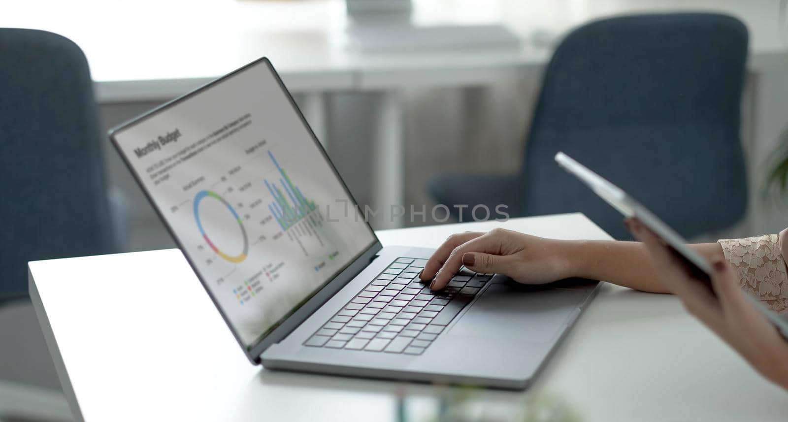 Closeup image of an Asian business woman working and typing on laptop keyboard in office.