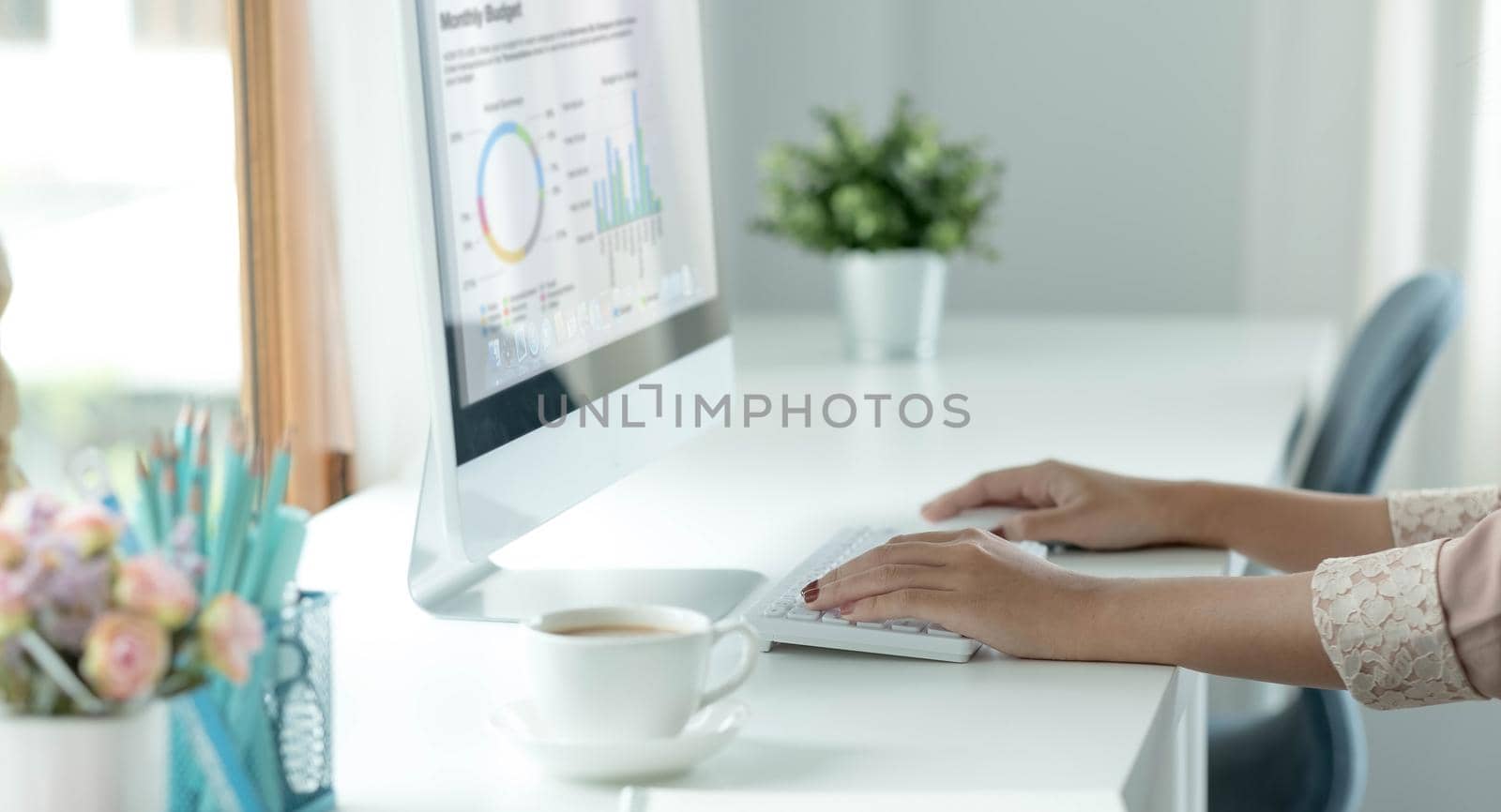 Closeup image of an Asian business woman working and typing on laptop keyboard in office.