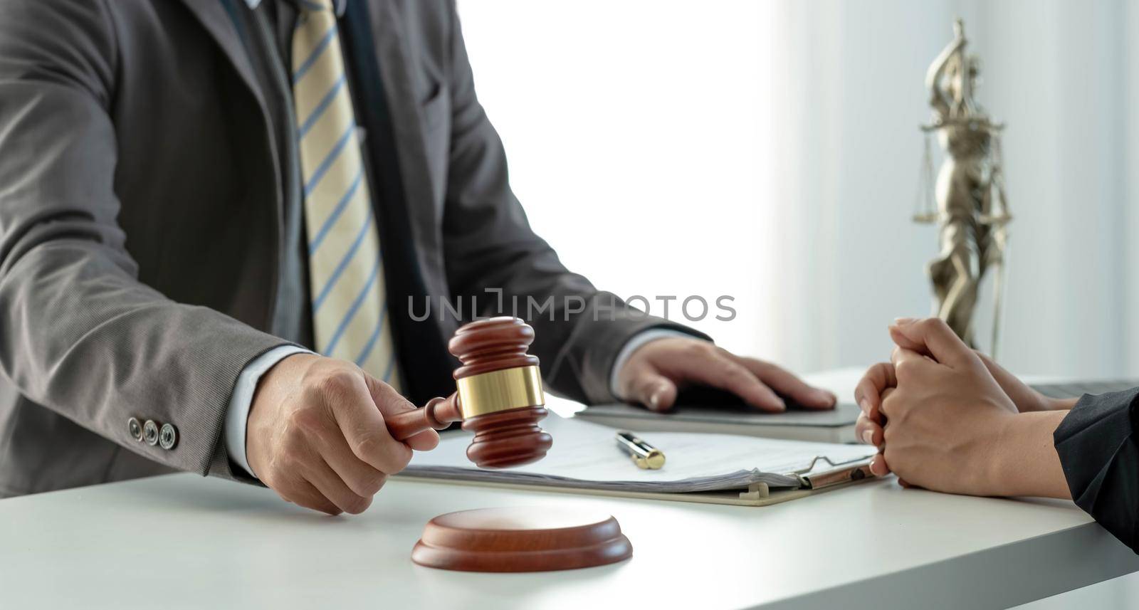 Business and lawyers discussing contract papers with brass scale on desk in office. Law, legal services, advice, justice and law concept picture with film grain effect by wichayada