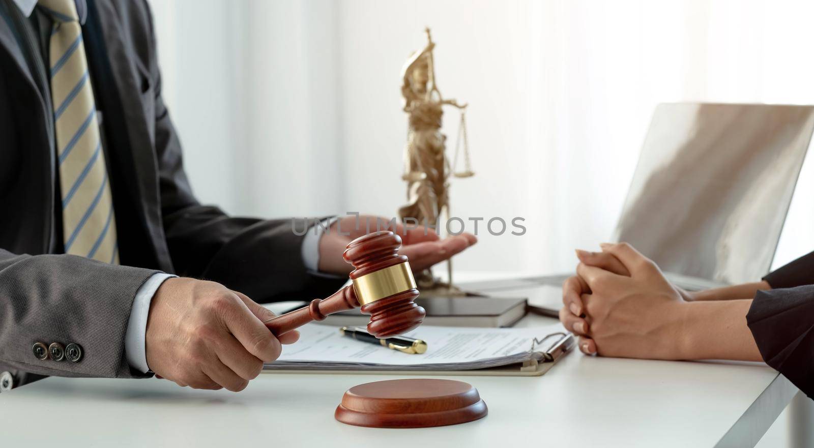 Business and lawyers discussing contract papers with brass scale on desk in office. Law, legal services, advice, justice and law concept picture with film grain effect.