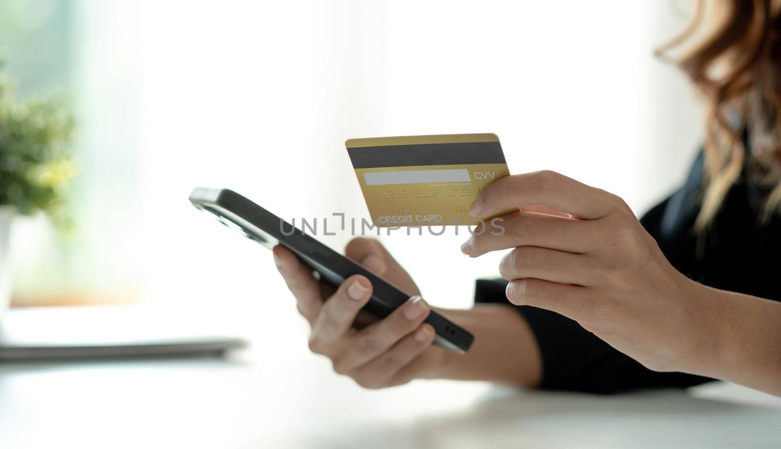 Asian woman checking online order details on smartphone Close control of credit card information entered..