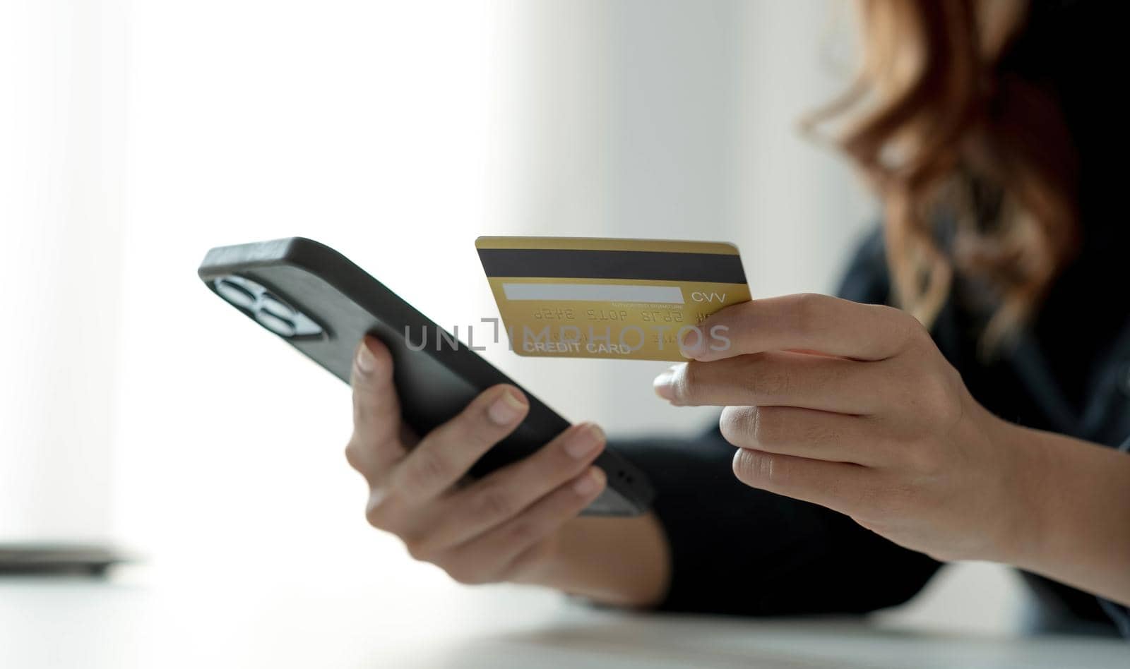 Asian woman checking online order details on smartphone Close control of credit card information entered. by wichayada