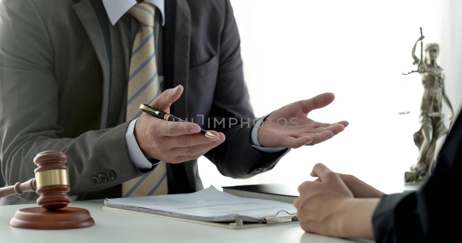 Business woman and lawyers discussing contract papers with brass scale on wooden desk in office. Law, legal services, advice, Justice concept..